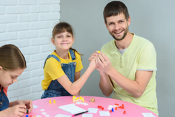 Image showing Girl and dad hold chips while playing a board game