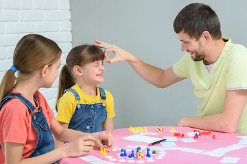 Image showing Dad punches a girl who lost in a board game