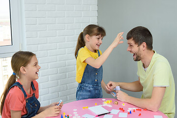 Image showing Daughter is going to punch dad in the forehead for a loss in a board game