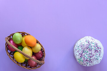 Image showing Top view on basket with easter eggs and on cake, purple background