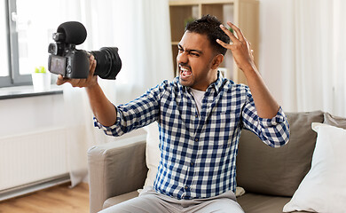 Image showing male video blogger with camera blogging at home