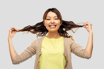 Image showing happy asian woman with waving hair