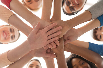 Image showing close up of international women stacking hands