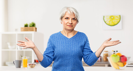 Image showing senior woman having shrugging in kitchen