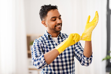 Image showing indian man putting protective rubber gloves on