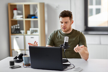 Image showing man with laptop and microphone at home office