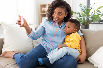 Image showing african mother with baby son taking selfie at home