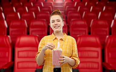 Image showing redhead teenage girl with popcorn at movie theater