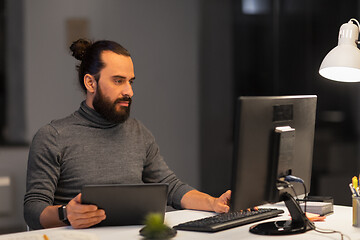 Image showing creative man with computer working at night office