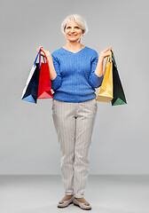 Image showing senior woman with shopping bags over grey