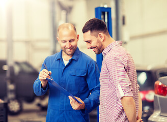 Image showing auto mechanic with clipboard and man at car shop