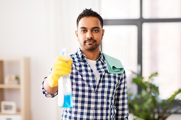 Image showing smiling indian man with detergent cleaning at home