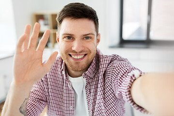 Image showing man or video blogger taking selfie and waving hand