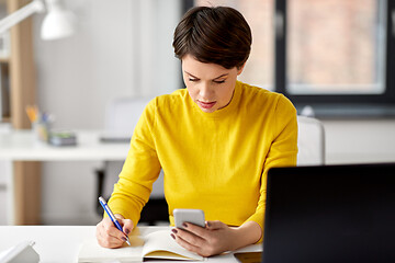 Image showing businesswoman with smartphone and notebook