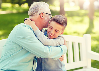 Image showing grandfather and grandson hugging at summer park