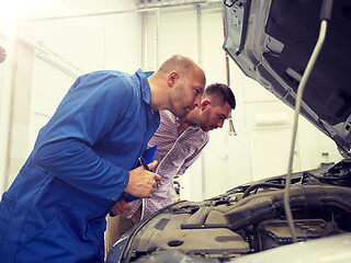 Image showing auto mechanic with clipboard and man at car shop