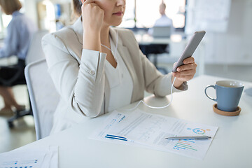 Image showing businesswoman with earphones and smartphone
