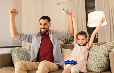 Image showing father and daughter playing video game at home