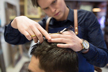 Image showing male hairdresser cutting hair at barbershop