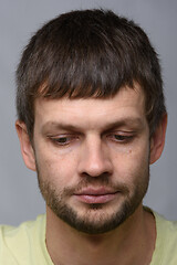 Image showing Close-up portrait of a grieved downcast European-looking man who puffed out his cheeks