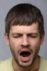 Image showing Close-up portrait of a yawning man of European appearance