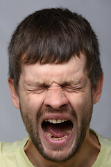 Image showing Close-up portrait of a yawning man of European appearance with wide open mouth