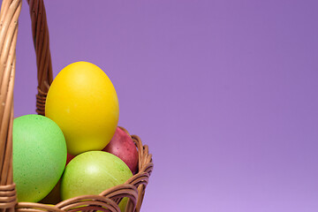 Image showing Colored easter eggs in a basket, empty space on the right