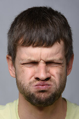 Image showing Portrait of a man who really does not like the smell, European appearance and close-up