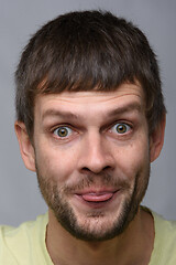 Image showing Portrait of a cheerful man of European appearance showing tongue, close-up