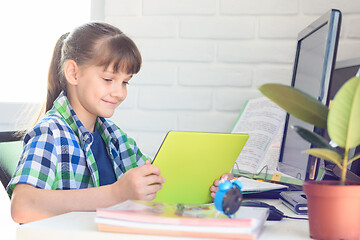 Image showing Girl studying at school at home, watching a video lesson online