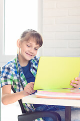 Image showing Girl studying in a tablet computer while sitting at a table at home