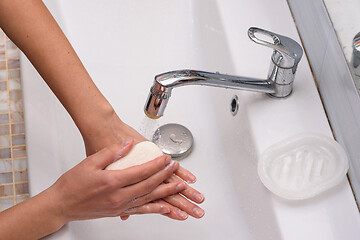 Image showing Girl soaping her hands with a soap