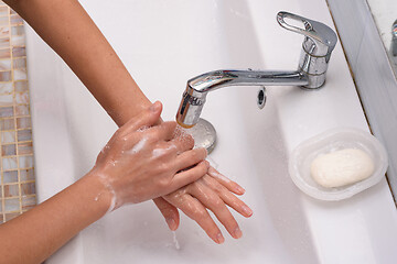 Image showing Girl washes hands with soap, close up