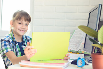 Image showing A ten year old girl happily looks at the screen of a tablet computer