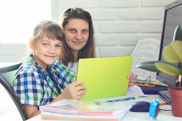 Image showing Girl and mom do homework online and looked into the frame