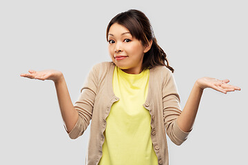 Image showing clueless asian woman shrugging