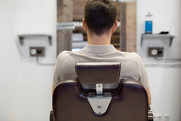 Image showing man sitting in chair at barbershop or hair salon