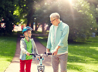 Image showing grandfather and boy with bicycle at summer park