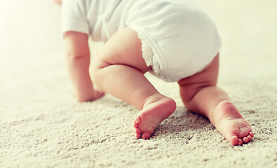 Image showing little baby in diaper crawling on floor at home