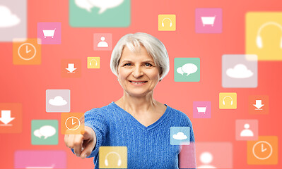 Image showing senior woman pointing to mobile app clock icon