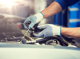 Image showing mechanic with dipstick checking motor oil level