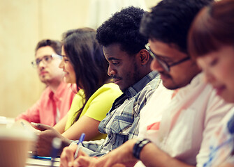 Image showing group of international students writing at lecture