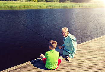 Image showing grandfather and grandson fishing on river berth