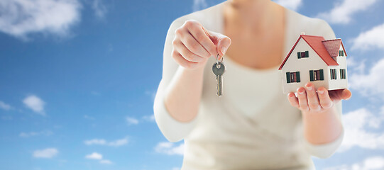 Image showing close up of hands holding house model and keys