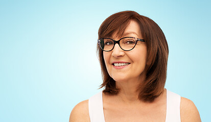 Image showing portrait of senior woman in glasses over blue