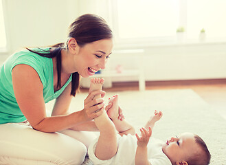 Image showing happy mother playing with little baby at home