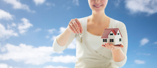 Image showing close up of hands holding house model and keys