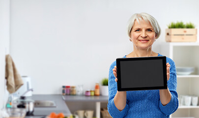 Image showing senior woman using tablet computer in kitchen