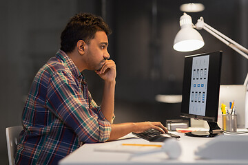 Image showing creative man with computer working at night office