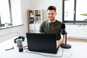 Image showing man with laptop and microphone at home office